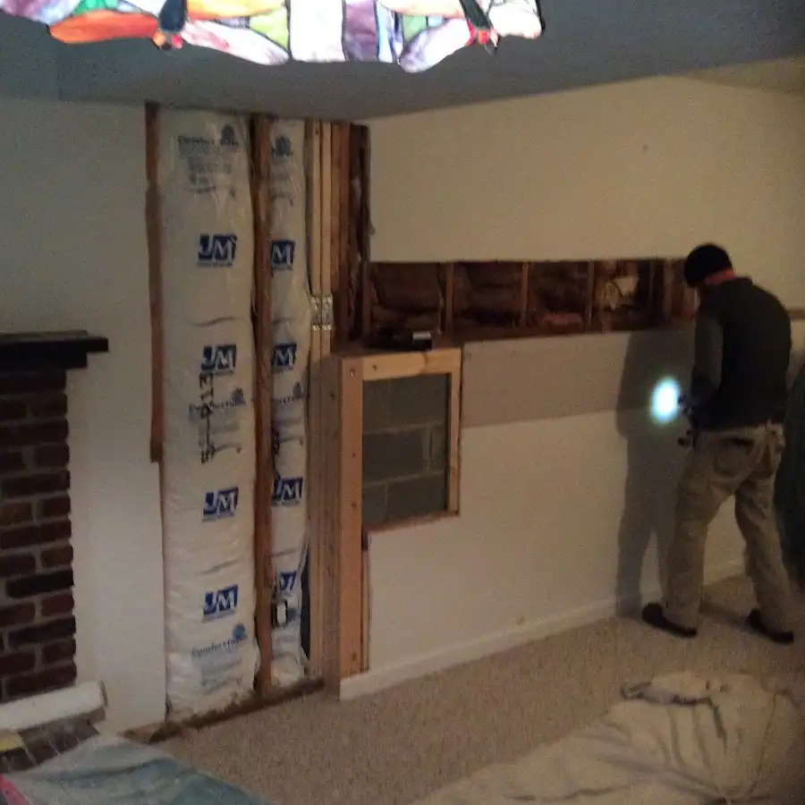 Restoration technician inspecting water damage in Garner